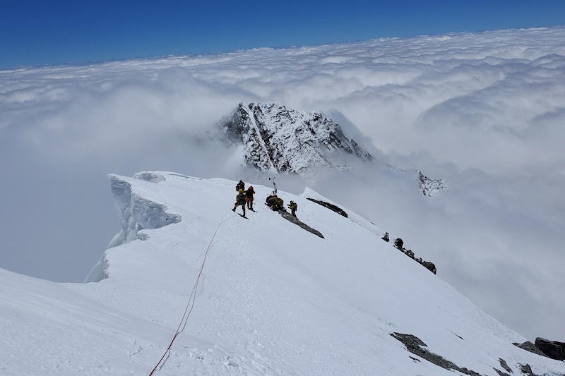Khumbu Valley, Nepal - 2022/05/09: Members of the 2022 Mt. Everest expedition team finalize the construction of the weather station at Bishop Rock. 

In May 2022, as part of the Perpetual Planet Expeditions partnership between National Geographic Society and Rolex, National Geographic Explorers along with a team of elite climbing Sherpa installed a new weather station just below the summit of Mount Everest at 8,810m/28,904ft. This work completes the most ambitious scientific undertaking on Mount Everest ever conducted that first installed a network of five weather stations, including the two highest in the world at the time in 2019.